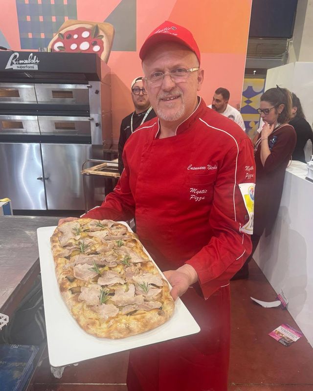Nicolò Cusumano con una pizza in pala al Campionato Mondiale della Pizza